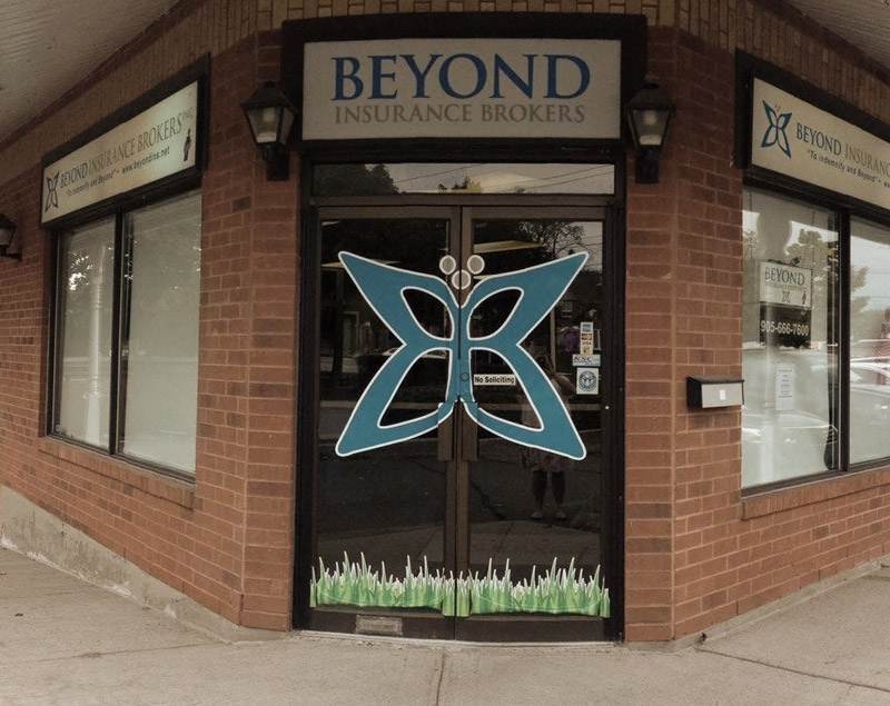 Photo of Beyond Insurance storefront with big logo on the door. 